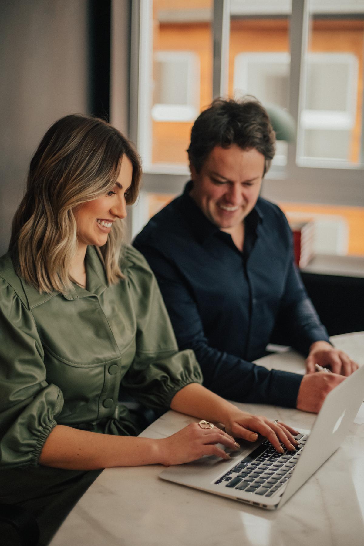 Equipe de pós-venda imobiliário auxiliando um cliente satisfeito em um escritório moderno.